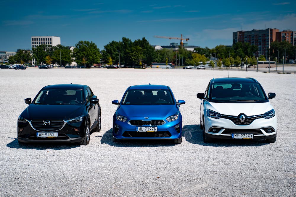 Czarny, niebieski i biały samochód na żwirowym parkingu