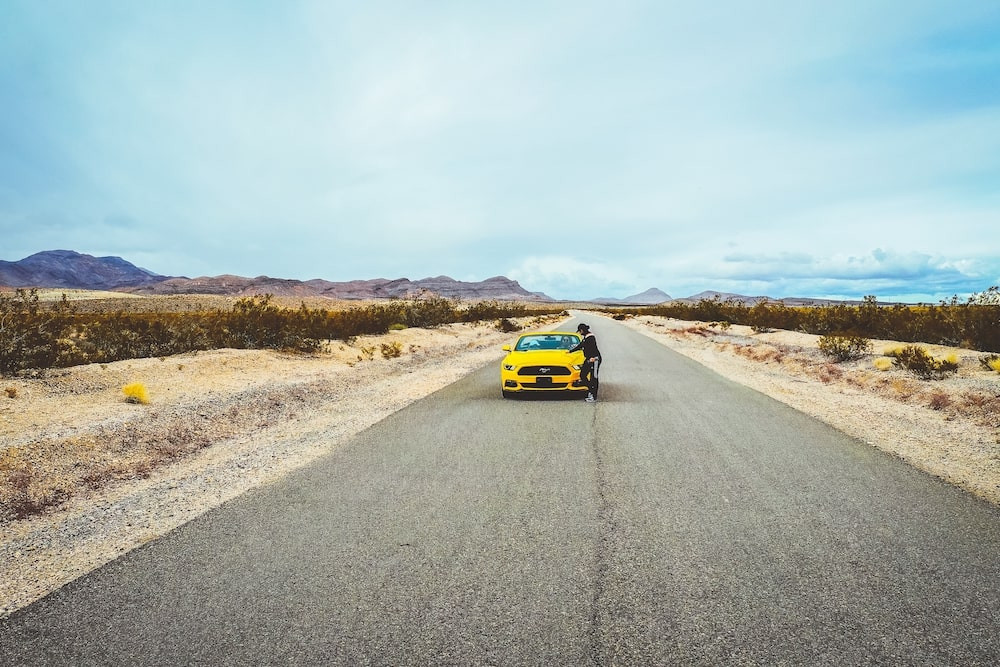 Żółty samochód zaparkowany na pustynnej drodze